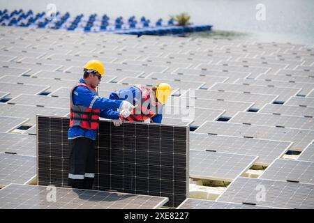 Photovoltaic engineers work on floating photovoltaics. Inspect and repair the solar panel equipment floating on the water. Stock Photo