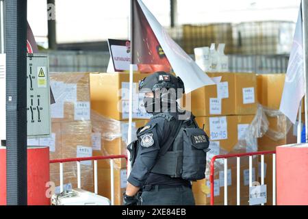 Bangkok. 26th June, 2024. A police officer stands guard in front of the illegal drugs to be burned at Bang Pu in Thailand's Samut Prakan Province, June 26, 2024. Thailand burned more than 20 tons of confiscated narcotic drugs worth 6.45 billion baht (about 175 million U.S. dollars) on Wednesday to mark the International Day Against Drug Abuse and Illicit Trafficking, authorities said. Credit: Rachen Sageamsak/Xinhua/Alamy Live News Stock Photo