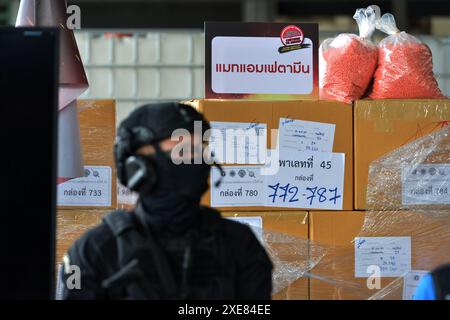 Bangkok. 26th June, 2024. A police officer stands guard in front of the illegal drugs to be burned at Bang Pu in Thailand's Samut Prakan Province, June 26, 2024. Thailand burned more than 20 tons of confiscated narcotic drugs worth 6.45 billion baht (about 175 million U.S. dollars) on Wednesday to mark the International Day Against Drug Abuse and Illicit Trafficking, authorities said. Credit: Rachen Sageamsak/Xinhua/Alamy Live News Stock Photo