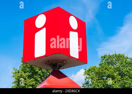 Bright red decorative information desk cube with the letter I on a blue sky background. Stock Photo