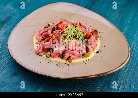 Fried cured and sliced veal tongue with mashed potatoes Stock Photo