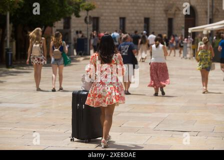 June 26, 2024, Malaga, Spain: A tourist is seen pushing a suitcase at Alcazabilla street, amid a context of increasing rejection of mass tourism. Malaga has experienced significant growth in mass tourism and an increase in the number of tourist apartments in the city centre and neighborhoods. These factors have resulted in rising rental and housing prices. Local neighbourhood associations and organisations are calling for measures to be introduced to limit rental prices and the impact of mass tourism. (Credit Image: © Jesus Merida/SOPA Images via ZUMA Press Wire) EDITORIAL USAGE ONLY! Not for Stock Photo