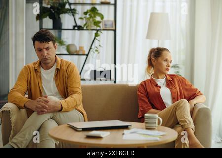 Couple sitting on sofa in the living room in silence they having conflict in their family Stock Photo
