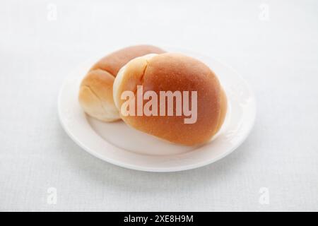 butter bread table rolls on plate isolated on table Stock Photo