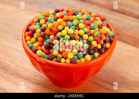 A Bowl of Small Ball Fruit Flavored Breakfast Cereal on a Wooden Kitchen Table Stock Photo