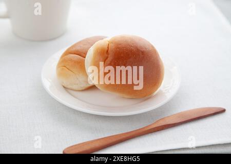 butter bread table rolls on plate isolated on table Stock Photo