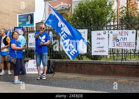 Cottbus, Germany. 26th June, 2024. Protesters demonstrate for peace opposite the Cottbus State Theater building. A ceremony is being held here today to mark the 110th anniversary of the Carl-Thiem-Klinikum Cottbus under the motto 'Tradition meets future'. The 'Vereinigte Städtische und Thiemsche Heilanstalt' was inaugurated on June 27, 1914. Credit: Frank Hammerschmidt/dpa/Alamy Live News Stock Photo