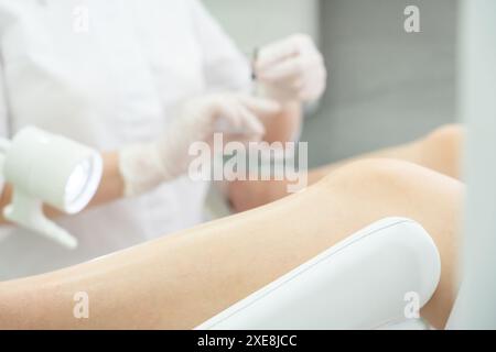 Gynecologist makes an injection to patient in gynecology chair Stock Photo