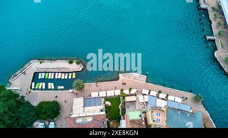 Riva del Garda, Lake Garda, Italy - June 25, 2024: Pedal boats or pedal boat rental from above in Riva del Garda. Here tourists can hire boats for trips on Lake Garda and paddle on the lake. *** Tretboote bzw. Tretbootvermietung von oben in Riva del Garda. Hier können sich Touristen Boote für Studen auf dem Gardasee ausleihen und auf dem See paddeln. Stock Photo