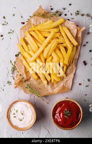 Golden yummy deep french fries on kraft baking sheet paper Stock Photo