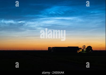 Scenic view of noctilucent clouds or NLC above a farm during the period of the shortest nights in June Stock Photo