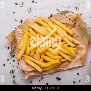 Golden yummy deep french fries on kraft baking sheet paper Stock Photo