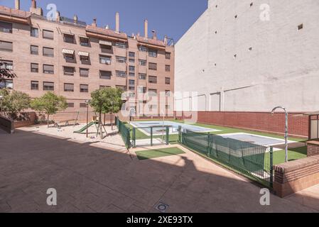 A swimming pool and a grassy playground in the common interior area of an urban residential building Stock Photo