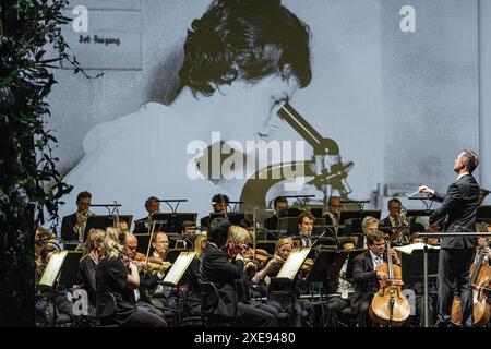 Cottbus, Germany. 26th June, 2024. General Music Director Alexander Merzyn (r) conducts the Cottbus State Theatre Philharmonic Orchestra at the ceremony to mark the 110th anniversary of the Carl-Thiem-Klinikum Cottbus. The 'Vereinigte Städtische und Thiemsche Heilanstalt' was inaugurated on June 27, 1914. Credit: Frank Hammerschmidt/dpa/Alamy Live News Stock Photo