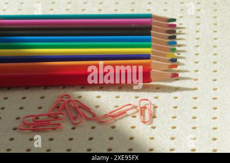Pencils in different colors and clips on light background Stock Photo