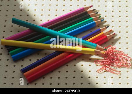 Pencils in different colors and clips on light background Stock Photo