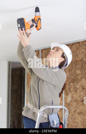 female builder using corless drill Stock Photo