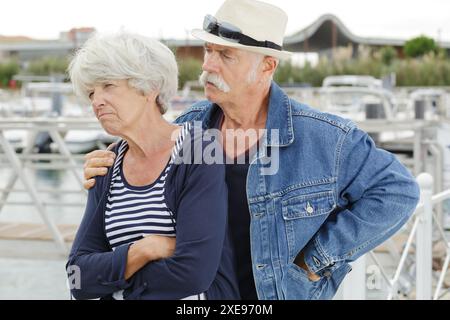 senior man trying to console grumpy wife Stock Photo