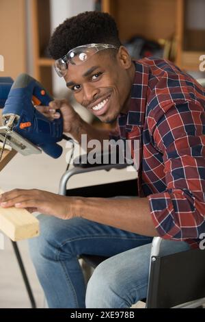 disabled worker in wheelchair in a carpenters workshop Stock Photo