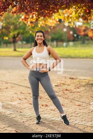 Woman Posing in Athletic Wear Under Autumn Tree Stock Photo