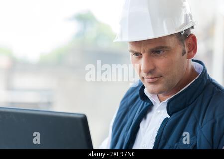 male engineer managing process with laptop Stock Photo
