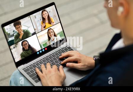 Man Participating in Video Call With Four People on Laptop Stock Photo