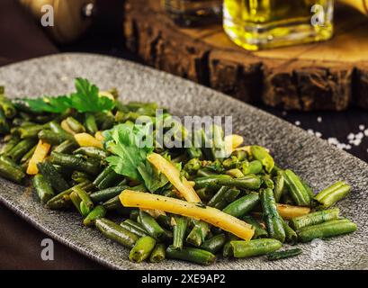 Fried wok green beans with onions and spices Stock Photo