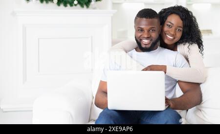 Couple Using Laptop on White Couch Stock Photo