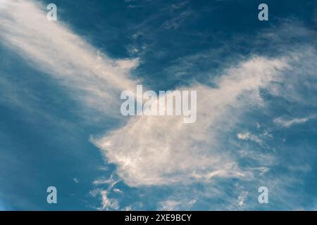 Curly white cirrus clouds on a blue sky for use as abstract backgrounds and textures. Stock Photo