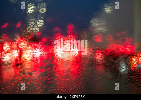 Rainy Night Traffic Lights Bokeh on Windshield Stock Photo