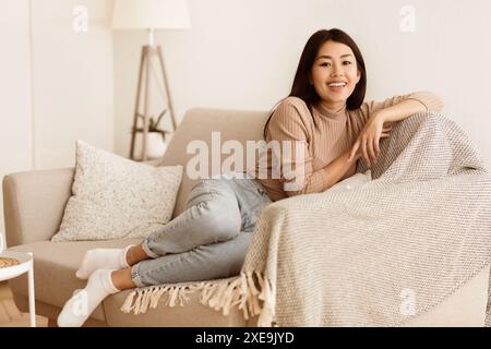 Happy Teen Girl Resting on Comfortable Sofa Stock Photo