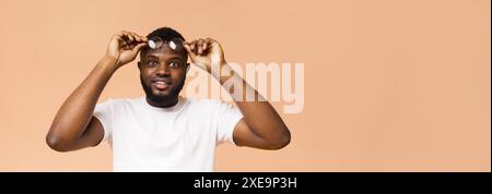 Smiling Man Wearing Glasses Against A Peach Background Stock Photo