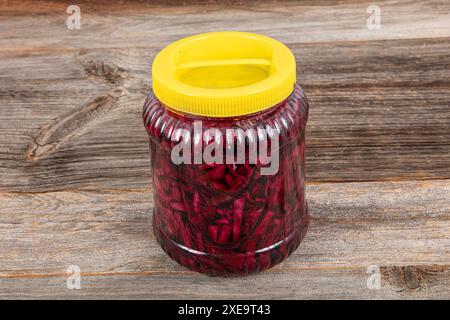 A jar of pickled red cabbage and sauerkraut in a plate, photographed on a wooden background. Healthy lifestyle concept. Stock Photo