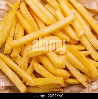 Golden yummy deep french fries on kraft baking sheet paper Stock Photo