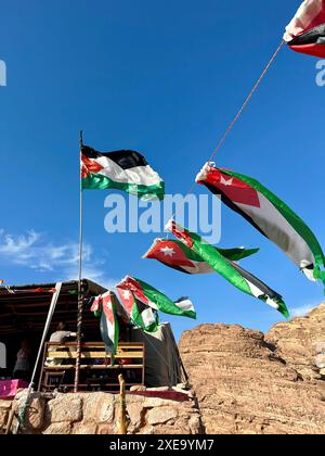 Flags of Jordan Fluttering Near Petra: Echoes of History in the Desert Breeze Stock Photo