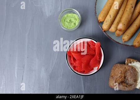 Wasabi sauce on a gray background ginger root bread farmer's sausages on a gray background top angle place for text copyspace. Stock Photo