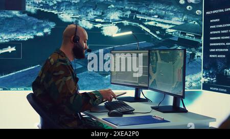 Military operator transmitting gps coordinates of hostile ships to national guard, providing real time data from surveillance CCTV system. Army officer works in power base control center. Camera B. Stock Photo