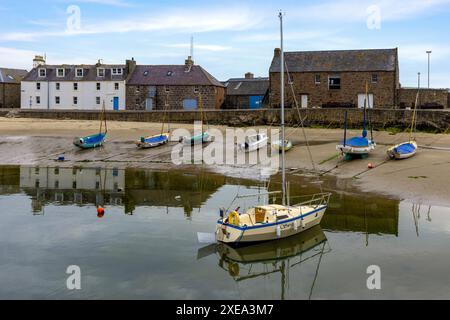 Stonehaven Harbour in Aberdeenshire is a picturesque scene of colourful boats nestled in the harbour, with a backdrop of historic buildings. Stock Photo