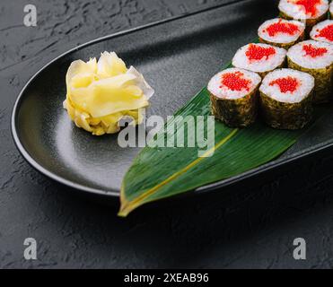 Maki Sushi with red caviar on black plate Stock Photo