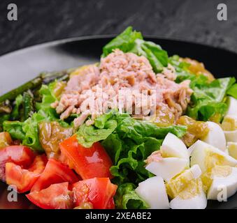 Tuna and vegetable salad on black plate Stock Photo