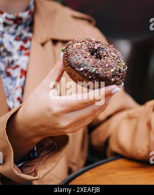 Female hands are holding a donut Stock Photo