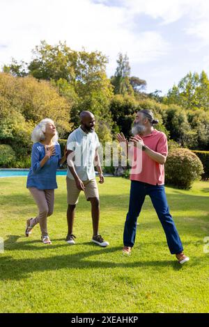 Diverse group of friends walking and talking together in park Stock Photo