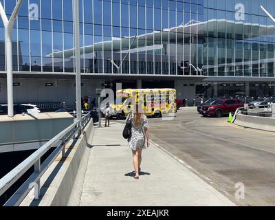 Departure level of Tom Bradley International Terminal with building reflected in window and polka dot shuttle bus to parking lot at LAX, Los Angeles, California, USA Stock Photo