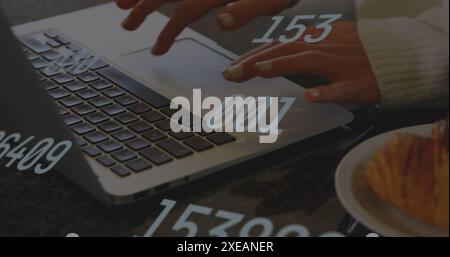 Image of multiple changing numbers over caucasian woman typing on laptop and handing plate Stock Photo