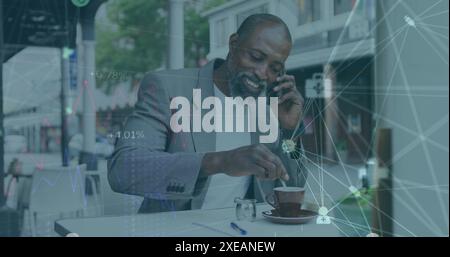 Image of globe of medical icons over african american man talking on smartphone at a cafe Stock Photo