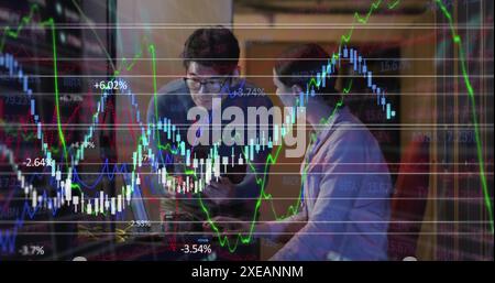 Image of financial data processing against diverse male and female engineer working in server room Stock Photo