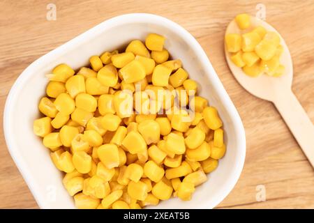 Sweet corn kernels in bowl on wooden table still life Stock Photo