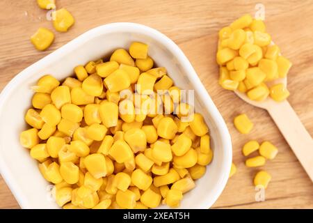 Sweet corn kernels in bowl on wooden table still life Stock Photo