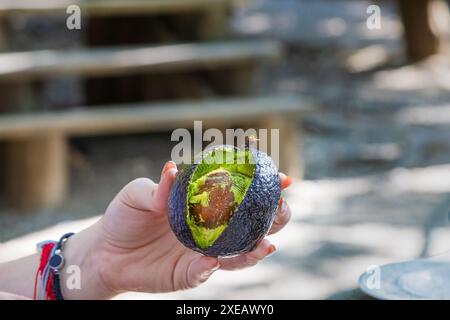 Opening, peeling, splitting and preparing a dressing with avocado. Stock Photo