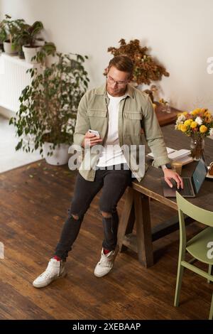 Portrait of a man in office, businessman making a phone call, having a conversation over the phone, receive a call, standing in Stock Photo